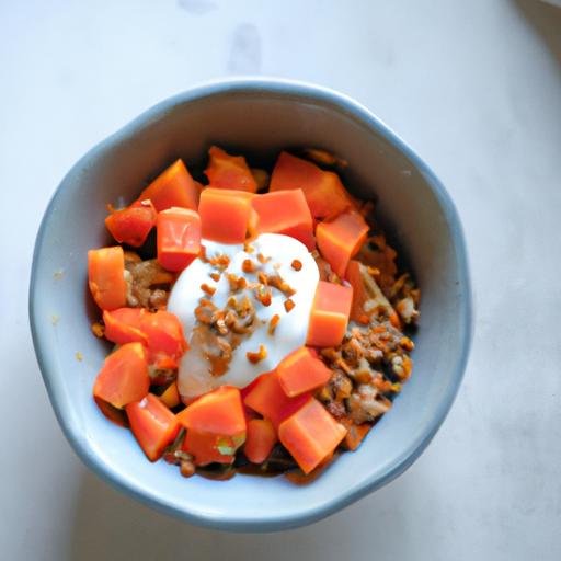 A delicious and nutritious breakfast bowl with papaya cubes, granola, and yogurt for a fiber-filled start to your day.