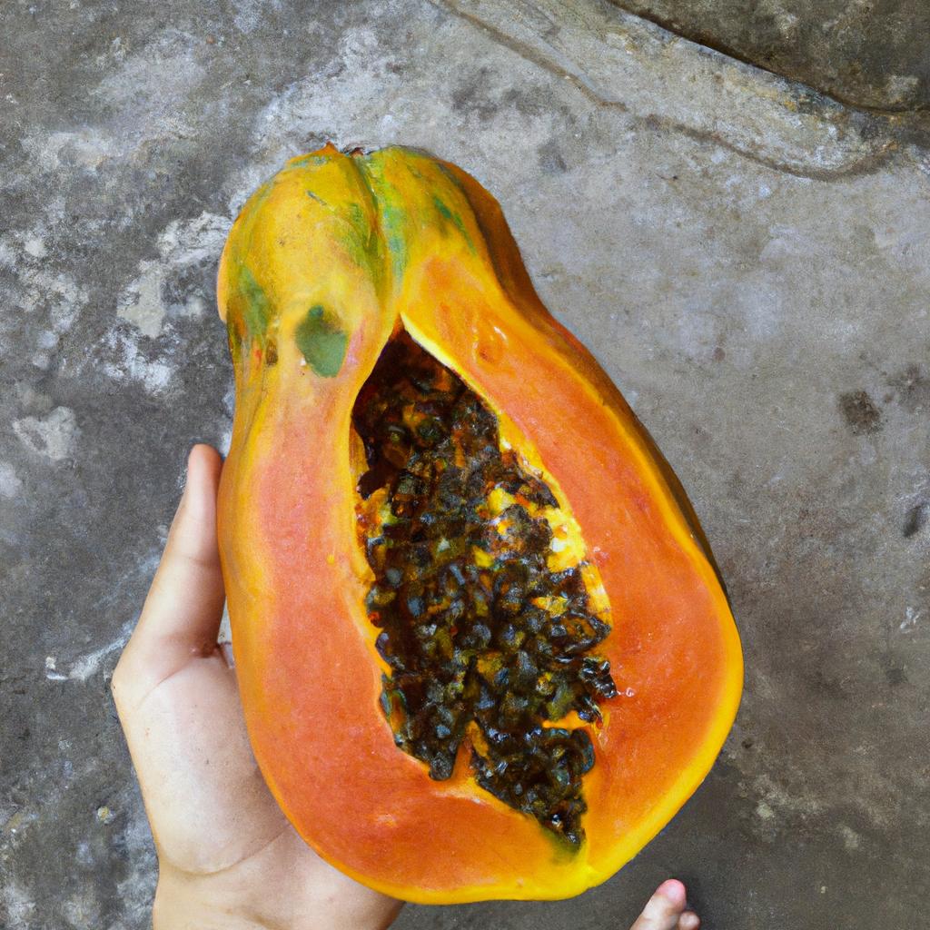 A person holding a perfectly ripe papaya fruit in their hand.